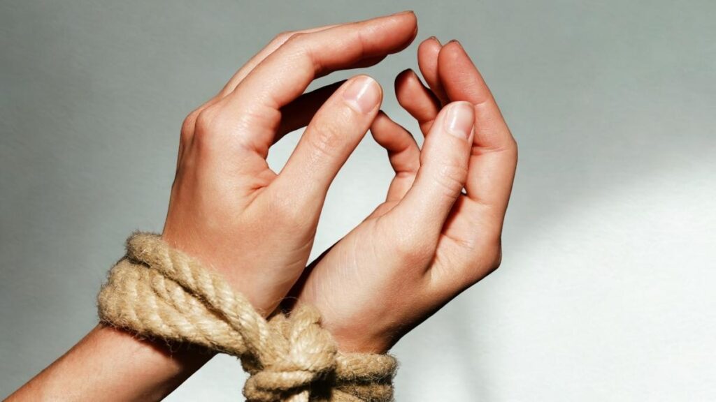 A woman's wrists tied with rope.
